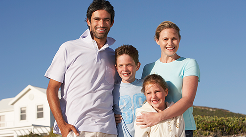 Smiling young family of four outdoors - Learn more about the Insurance Products and Services we offer